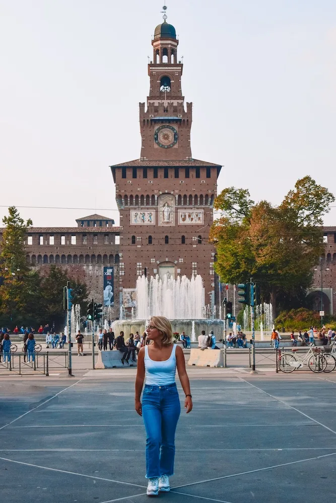Girl walking in front of Castello Sforzesco in Milan, Italy