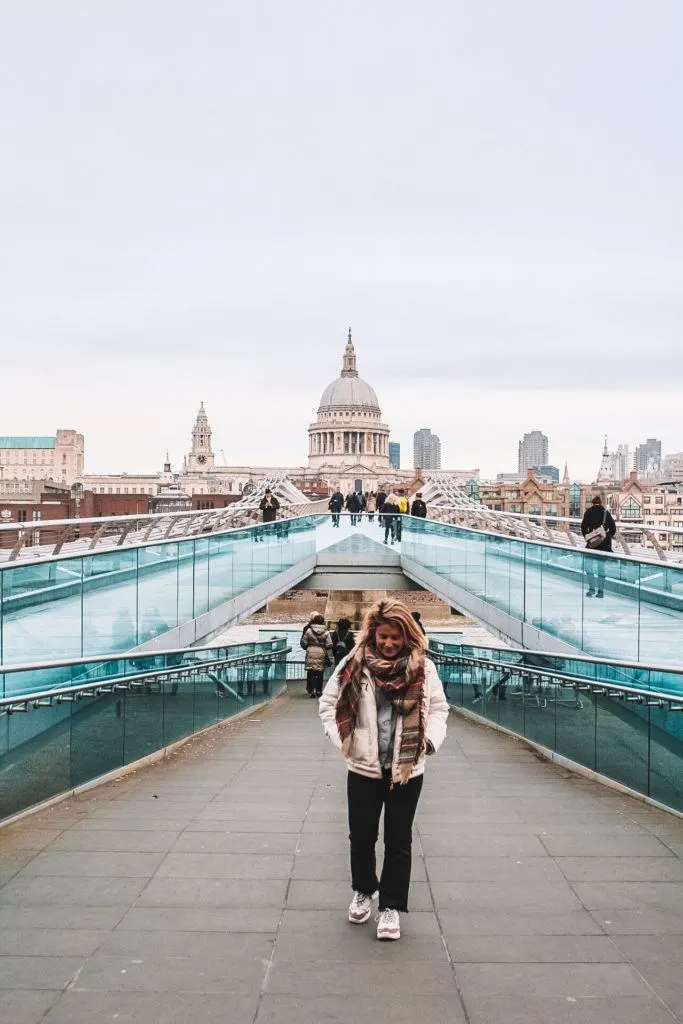 Girl walking along Millennium Bridge in London with St Paul's Cathedral in the back