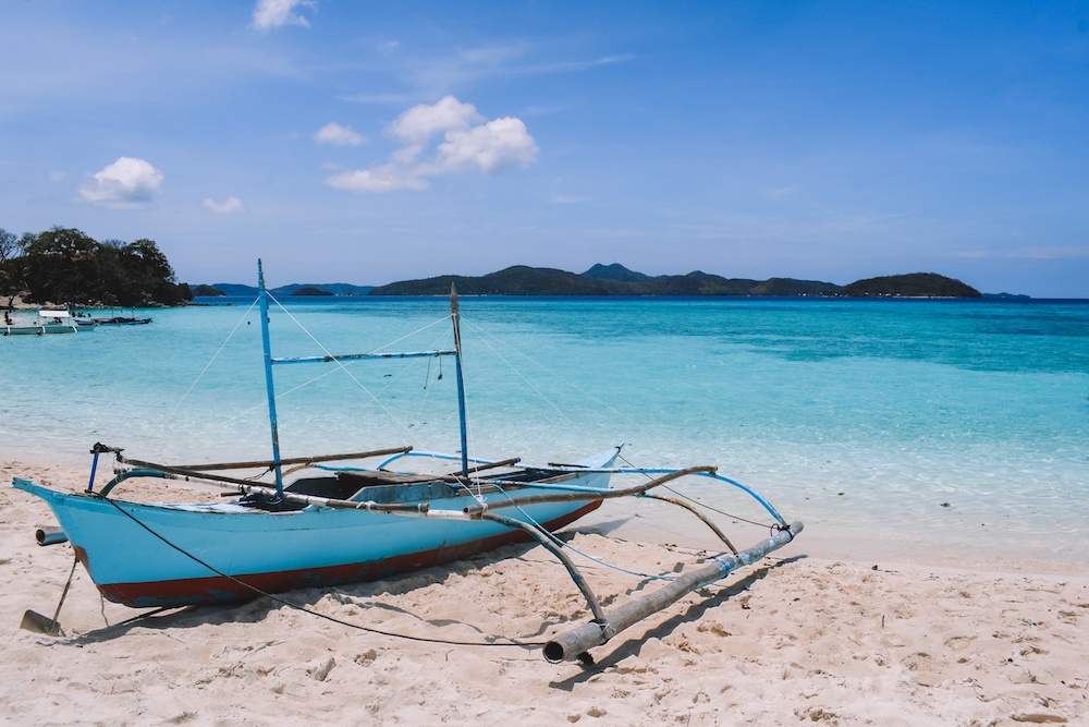 A traditional Filipino boat on the beach on Malcapuya Island