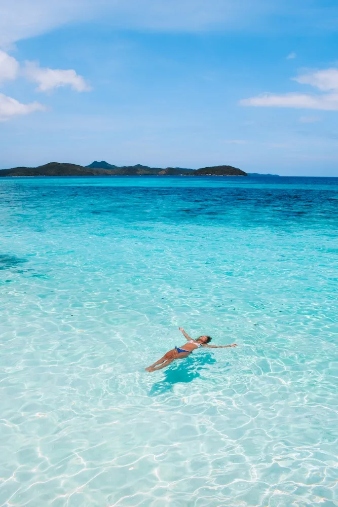 Floating in the crystal clear water of Malcapuya Island
