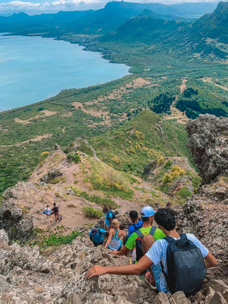 Single file group of people as they slowly climb back down Le Morne Brabant in Mauritius