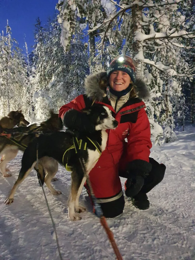 Getting to know my sledding tour husky dogs in full Lapland winter gear