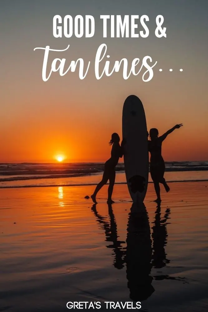 Photo of two girls holding a surf board on Santa Teresa Beach at sunset with text overlay saying "Good times and tan lines" - a beach quote perfect for your Instagram captions!