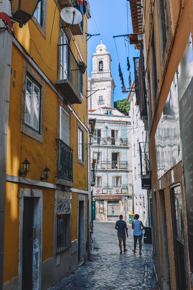 Walking along the narrow streets of Alfama neighbourhood in Lisbon