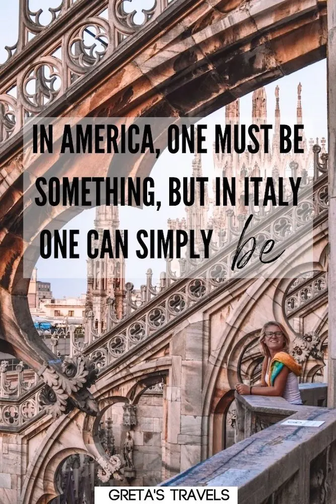 Photo of a blonde girl standing below the spires of the Duomo Cathedral in Milan, Italy, with text overlay saying “In America, one must be something, but in Italy one can simply be.” - one of my favourite quotes about the Italian lifestyle