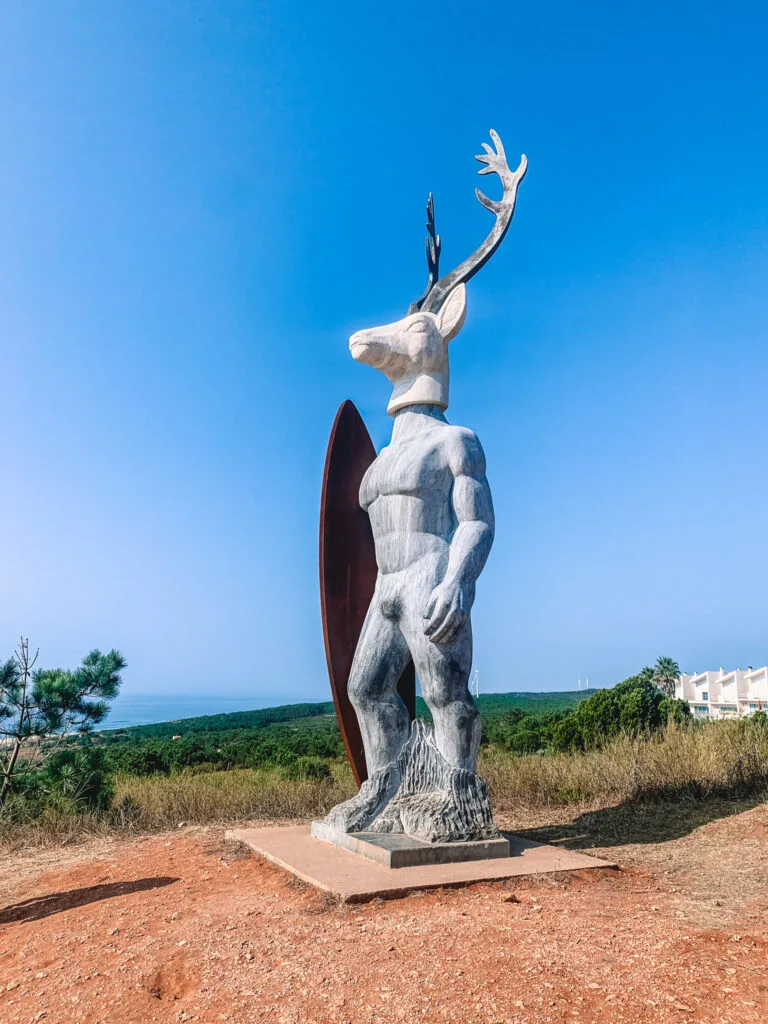 Veado - the famous deer-headed statue holding a surf board leading up to Nazaré Lighthouse