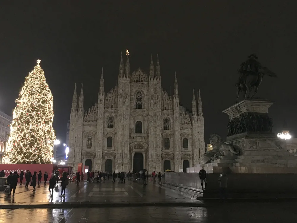 The Duomo of Milan, Italy, by night with its iconic Christmas tree next to it