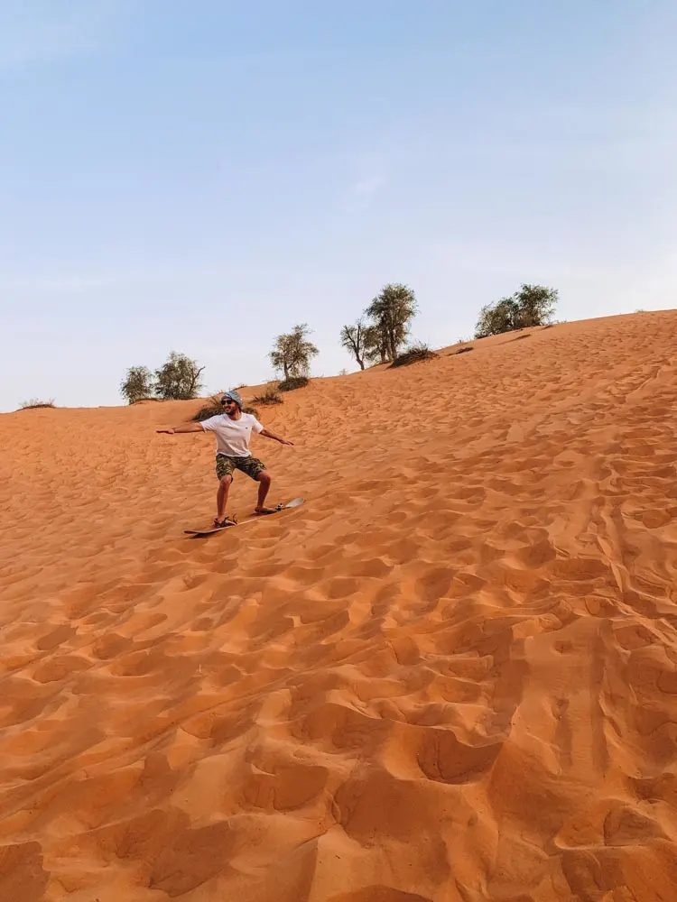 My friend speeding down a sand dune in Dubai with his sand board