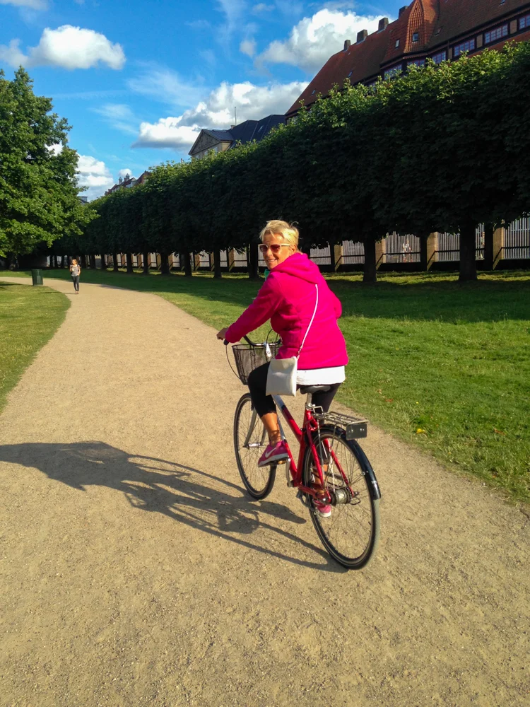 My mum cycling through the park next to Rosenborg Castle in Copenhagen