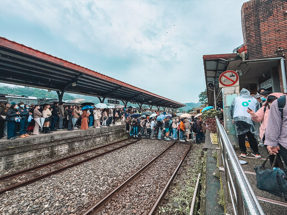 Crowds waiting with umbrellas at Shifen Railway Station Taipei Taiwan on a rainy day.