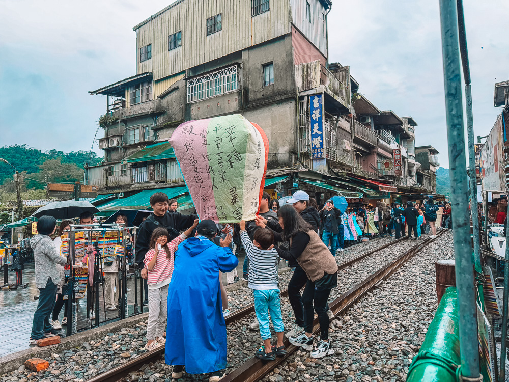 Family helping children release a lantern at Shifen Old Street Taipei Taiwan.