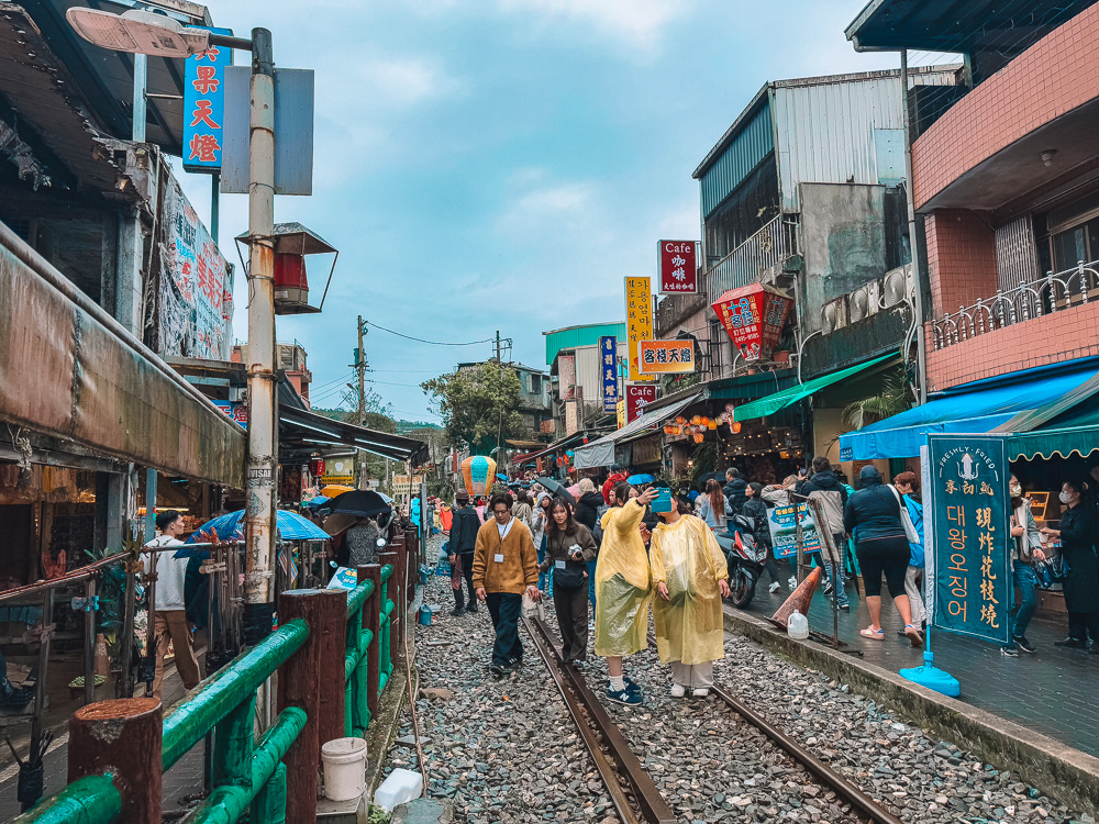 Crowds walking and shopping along train tracks at Shifen Old Street Taipei Taiwan.