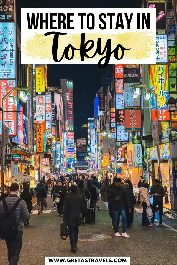 Photo of the busy streets and neon lights of Shinjuku at night with text overlay saying "where to stay in Tokyo"